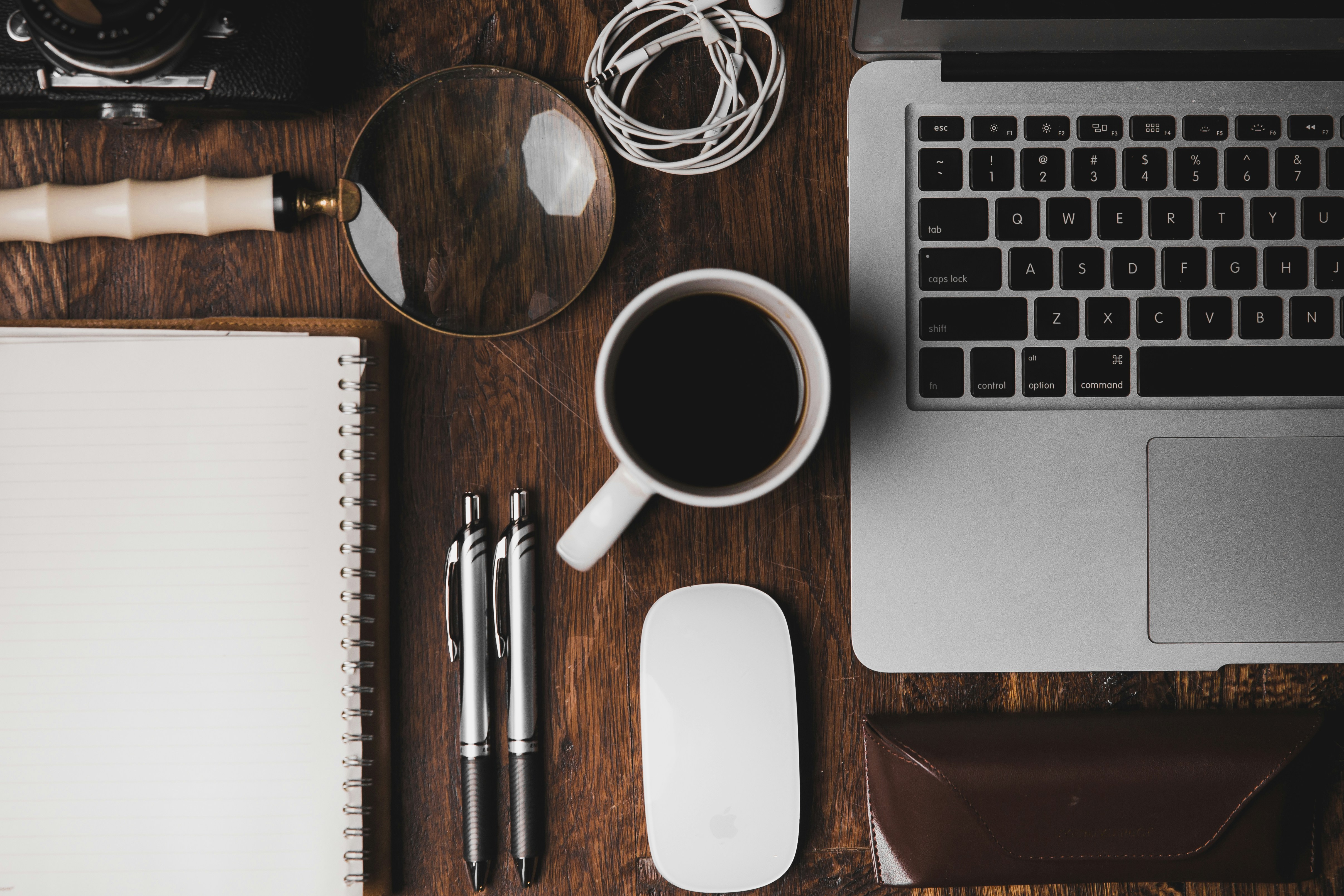Flat-lay desk with coffee, notebook and laptop